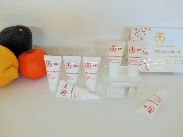 Arbonne RE9 Advanced anti-ageing mini tubes on white background with fruit