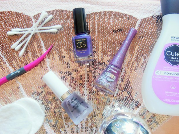 Nail polish bottles and accessories on a sequin background