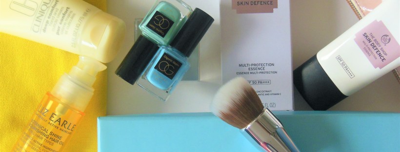 Beauty flatlay featuring tubes, bottles and brush