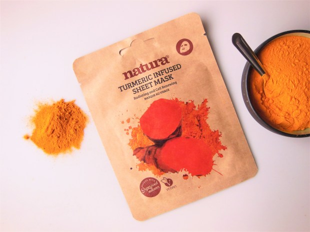 Turmeric sheet mask with turmeric powder in a bowl