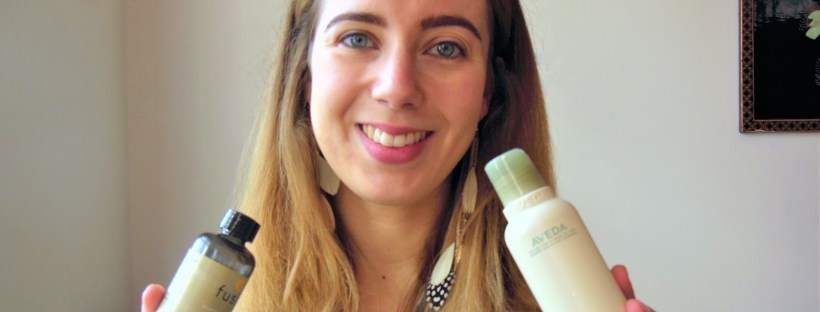woman holding a bottle of body oil and a bottle of body lotion
