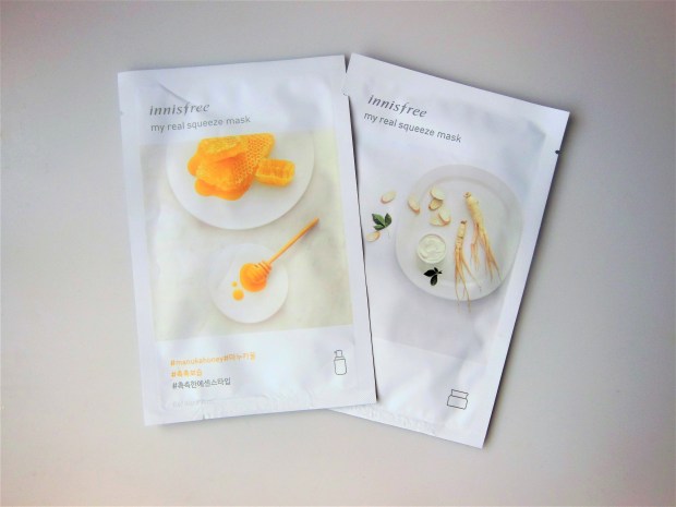 Two sheet masks on a grey background