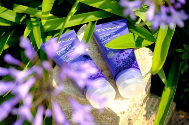 Two purple skincare tubes lying down on a rock
