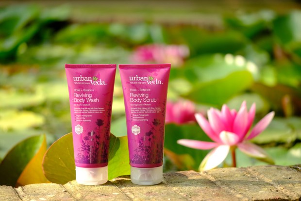 Two dark pink skincare tubes on a brick wall