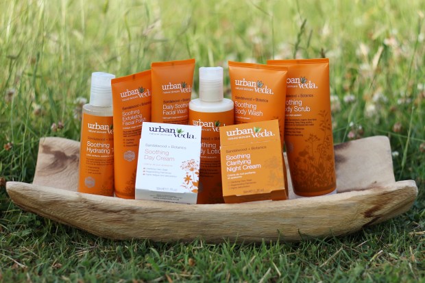 Skincare range on a wooden tray in the grass