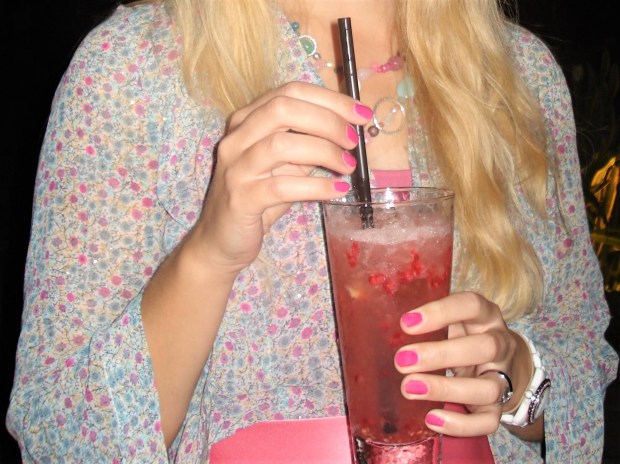 Woman with pink manicure holding drink